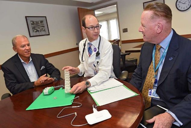 Dr. James Desemone, associate professor of medicine, center, holds a prototype of a sensor as he talks about the patient-wetness detection and notification system with Mike Hickey, vice president and chief of staff, Siena College, left, and Kevin Leyden, senior vice president of business development and strategic partnerships, Albany Medical Center, at the Biomedical Acceleration Commercialization Center at Albany Medical Center (Lori Van Buren / Times Union)