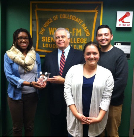 NYSBA President David Donovan (center) presents the Serving New York Award to AmeriCorps VISTA Fellows Sasha Miller (left) and Jimmy Bulmer '12 (right) and Bonner Service Leader Caylin Dadeo-Winick '15 (front) inside the WVCR studios.