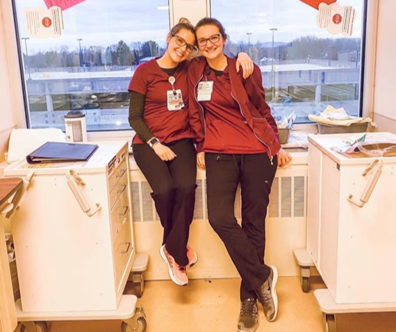 Carina and a fellow nurse hug at the hospital